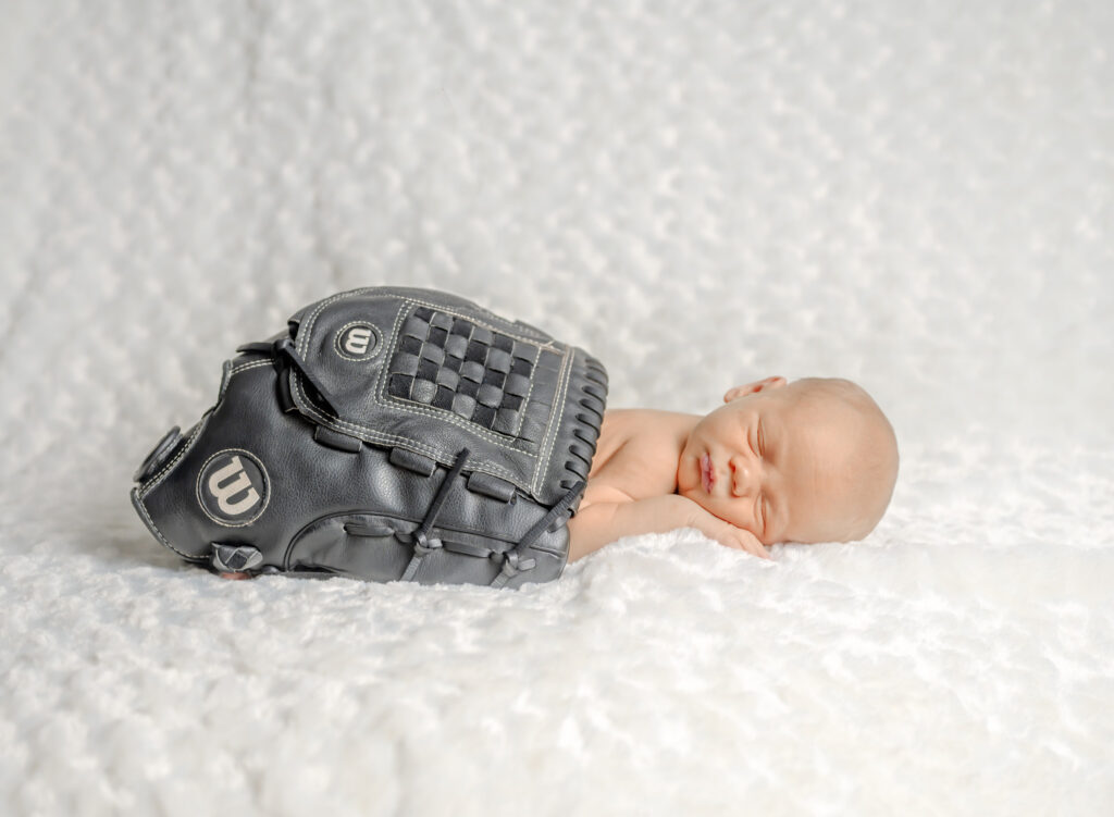 Newborn baby posed in baseball glove with baseball theme in St. Catharines studio